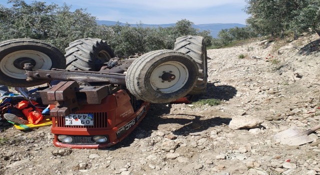 Devrilen traktörün altından yardım istedi